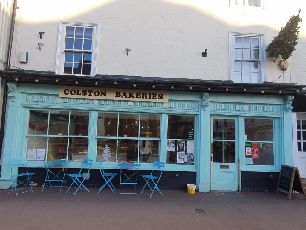 Upton Upon Severn 15 The front end of colston bakeries with table and chairs outside. painted in a light teal colour.