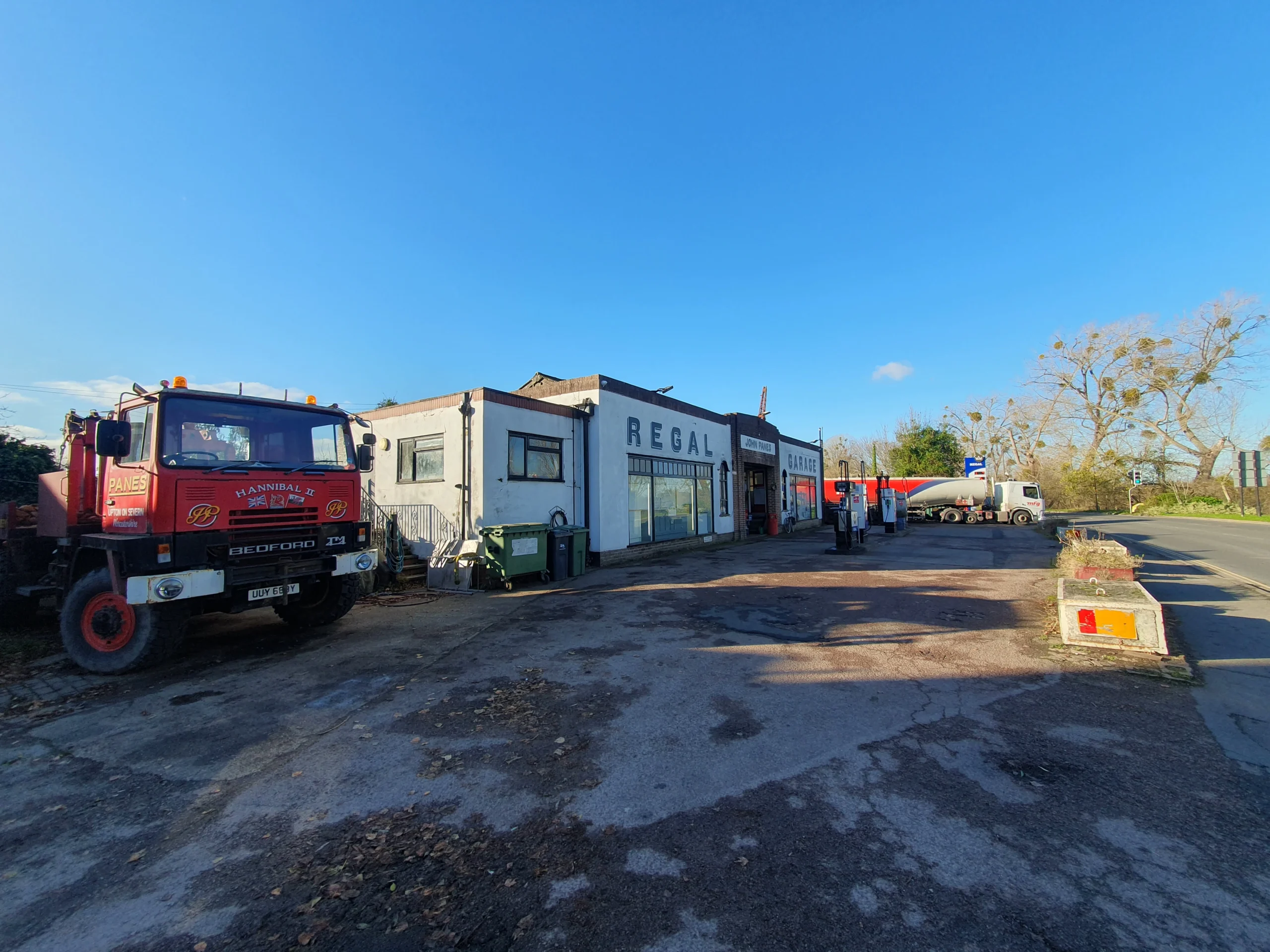 Upton Upon Severn 4 Original fuel station - one storey high and with only four pumps available with no shelter - receiving a fuel delivery and a red featured HGV parked alond side it.